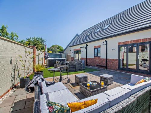 a patio with a couch and a table and a grill at 4 Bed in Saint Asaph 96246 in St Asaph