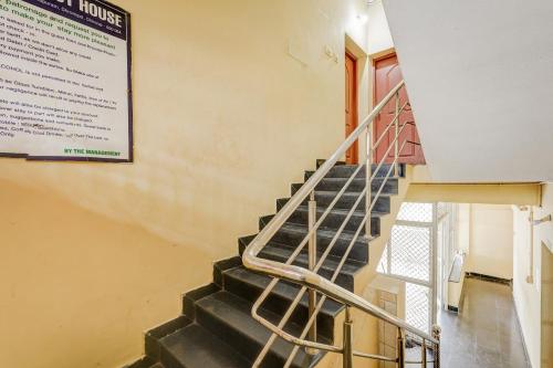 a staircase with a metal handrail in a building at Super Collection O Nanmangalam Lake Formerly Vasantham Guest House in Chennai