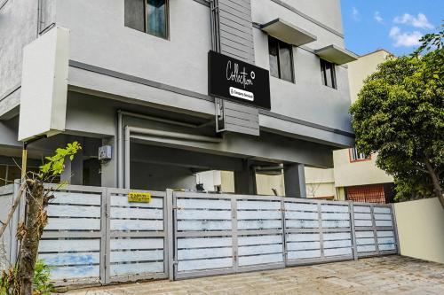 a building with a fence in front of it at Super Collection O Nanmangalam Lake Formerly Vasantham Guest House in Chennai