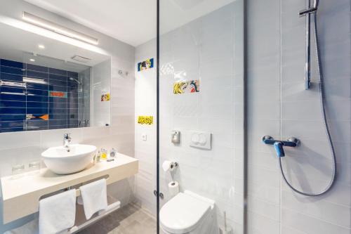 a bathroom with a shower and a toilet and a sink at Pharos Hvar Bayhill Hotel in Hvar