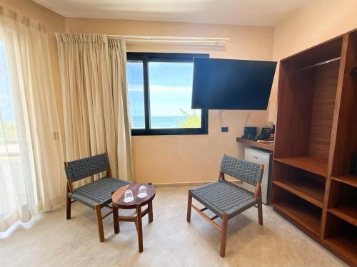 a room with two chairs and a table and a window at Ana y Jose Hotel & Beach Club Holbox in Holbox Island