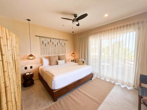 a bedroom with a bed and a ceiling fan at Ana y Jose Hotel & Beach Club Holbox in Holbox Island