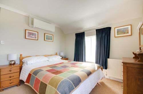 una camera da letto con un letto grande e una finestra di Owl Cottage a Holt