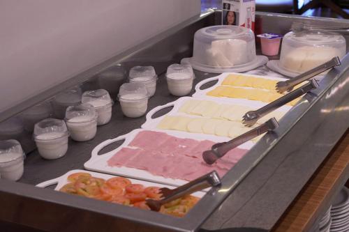 a drawer filled with different types of cheese and other foods at Castelo Inn Hotel in Goiânia