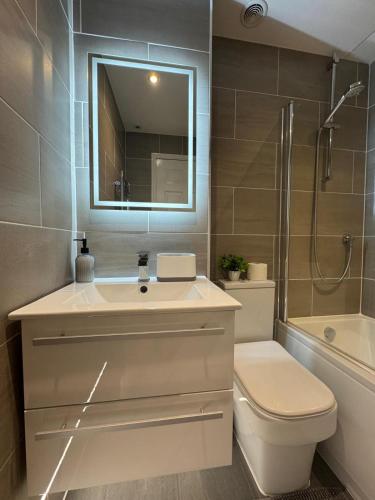 a bathroom with a sink and a toilet and a shower at Spotless Two-Bedroom Home with Garden and Parking in Stevenage