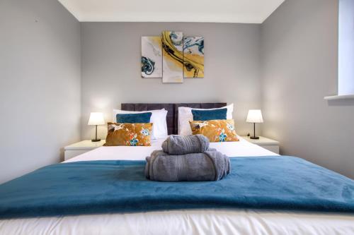 a bedroom with a large bed with a blue blanket at Spotless Two-Bedroom Home with Garden and Parking in Stevenage