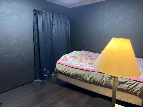 a small bedroom with a bed with a lamp at Tokurajyo - Vacation STAY 15813 in Akiruno