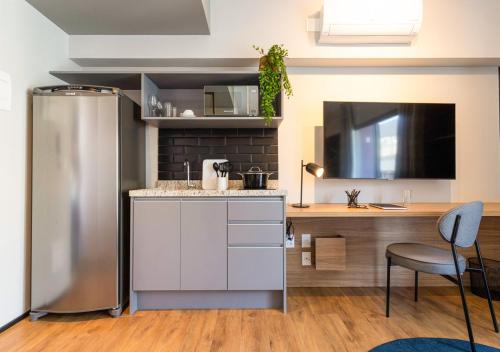 a kitchen with a stainless steel refrigerator and a table at Charlie Aeroporto Congonhas CGH in Sao Paulo
