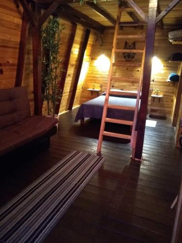 a bedroom with a bed and a ladder in a room at Villas Margarita, Mazamitla, Jalisco. in Mazamitla
