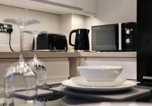 a kitchen with a microwave and a bowl on a counter at Spotless Two-Bedroom Home with Garden and Parking in Stevenage