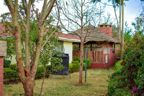 a small house with a fence in the yard at Riverside Spacious Getaway in Nairobi