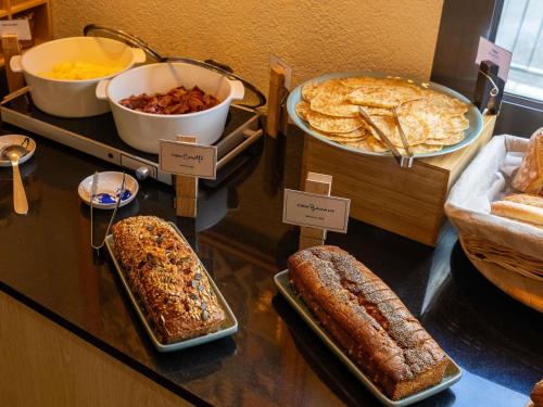 a buffet with different types of bread and other foods at Novotel Suites Paris Stade de France in Saint-Denis