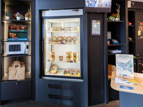 a blue refrigerator with food inside of it at Novotel Suites Paris Stade de France in Saint-Denis