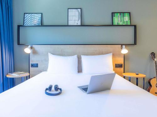 a bedroom with a bed with a laptop on it at Hotel ibis Bragança in Bragança
