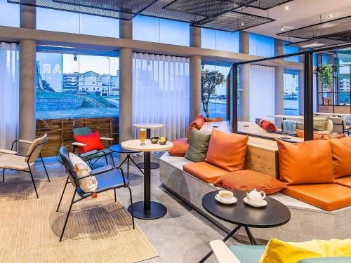 a living room with a couch and a table and chairs at Hotel ibis Bragança in Bragança