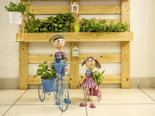 two figurines standing next to a bike with a plant at ibis Porto Centro São Bento in Porto