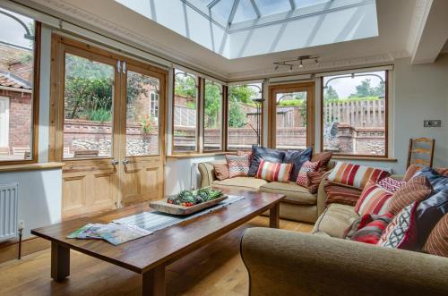 a living room with windows and a coffee table at St Lawrence House in Harpley
