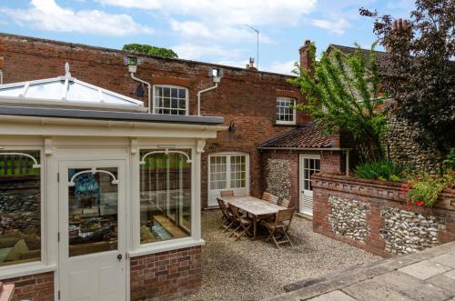 an extension to a brick house with a conservatory at St Lawrence House in Harpley