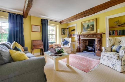 a living room with a couch and a fireplace at St Lawrence House in Harpley