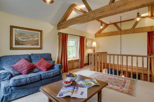 a living room with a blue couch and a table at St Lawrence House in Harpley