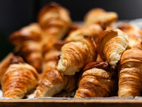 a pile of croissants and other pastries on a table at Hotel Mercure Lisboa in Lisbon