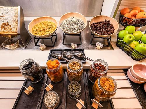 a table topped with bowls of different types of food at Hotel Mercure Lisboa in Lisbon
