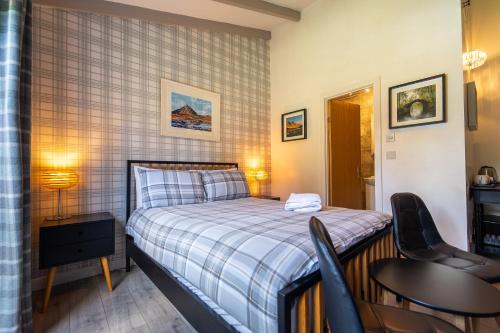 a small bedroom with a bed and a table and chairs at River Spean Retreat in Spean Bridge