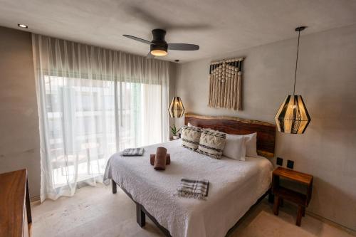 a bedroom with a bed and a large window at Bakal Studios in Tulum
