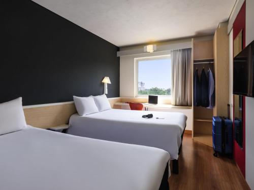 Una cama o camas en una habitación de Ibis Guadalajara Expo