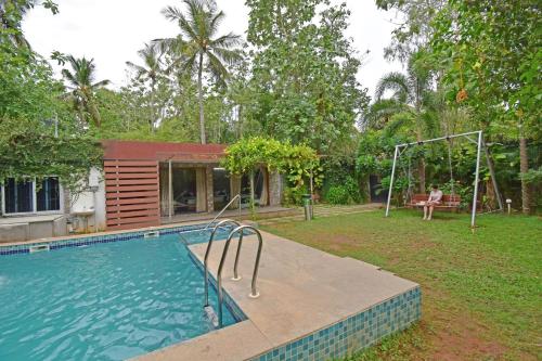 a house with a swimming pool in a yard at Aurobay Resorts Pondicherry in Auroville