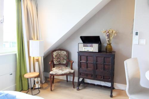 a room with a chair and a dresser and a staircase at Casa Galia Apartments in Nijmegen