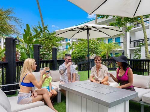 a group of people sitting around a table under an umbrella at OASIS BAY SUITES, Tampa, Busch Gardens, USF in Tampa