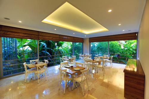 a restaurant with tables and chairs and large windows at Perle Apart Hotel in Alanya