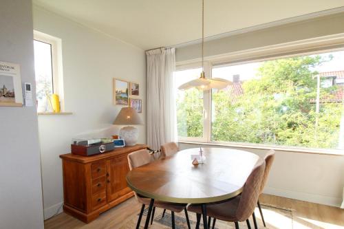 a dining room with a table and a window at Casa Galia Apartments in Nijmegen