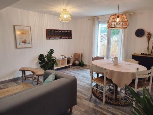 a living room with a table and a couch at Ty Pagaille Apartment and garden with terrace in Groix