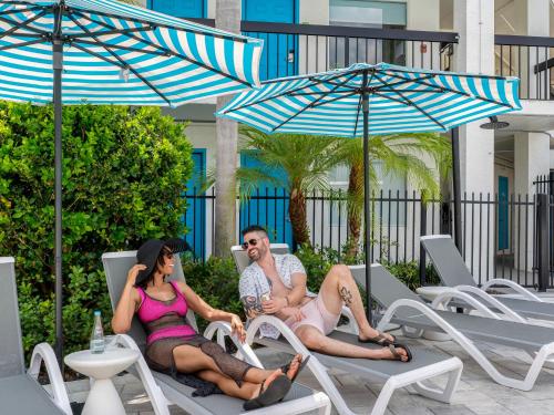 a group of people sitting in lawn chairs under umbrellas at OASIS BAY SUITES, Tampa, Busch Gardens, USF in Tampa