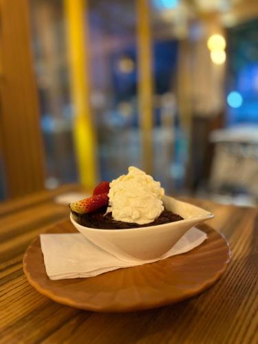 a bowl of dessert with whipped cream and strawberries on a table at Hostería Horizontes in Caucasia