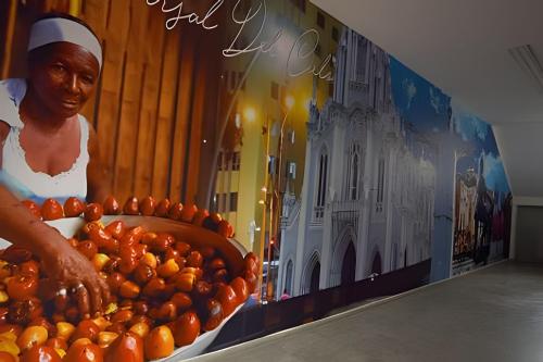 una pared con una pintura de una mujer y naranjas en 204 Espectacular Apartamento en granada, en Cali