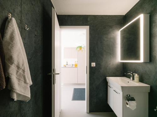 a bathroom with a white sink and a mirror at Apartment Baytrail in Seenähe in Spiez