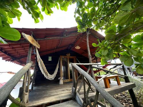 a house with a hammock in front of it at El Pajas in Puerto Velasco Ibarra
