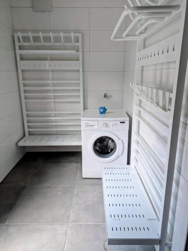 a laundry room with a washing machine and a washer at Bachbauer am Attersee in Weyregg