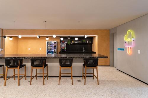 a kitchen with a large counter with chairs around it at Charlie Aeroporto Congonhas CGH in Sao Paulo