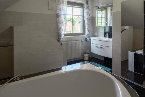 a bathroom with a large tub and a sink at Zum Stroama in Wies