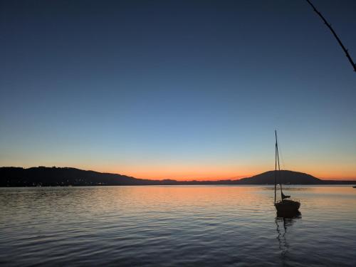 a boat sitting in the water at sunset at Bachbauer am Attersee in Weyregg