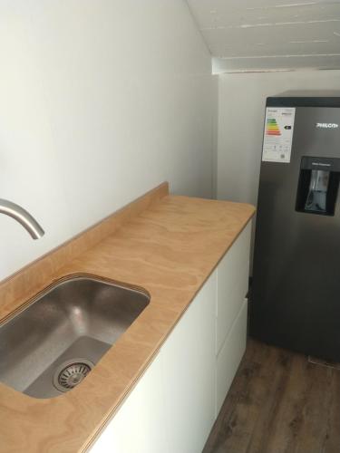 una cocina con fregadero y refrigerador en Hostería El Bosque, en Villa Gesell
