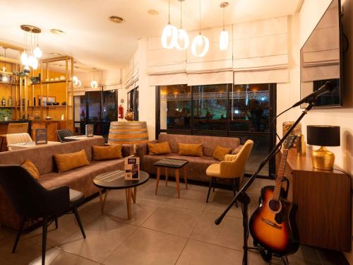 a living room with a couch and a guitar at Ibis Meknès in Meknès