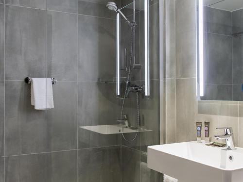 a bathroom with a sink and a shower at Novotel Szczecin Centrum in Szczecin