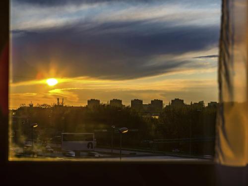 a view of the sunset from a window of a city at Ibis Częstochowa in Częstochowa