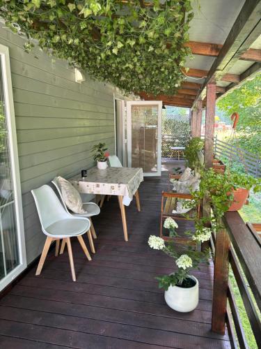 a patio with a table and chairs on a deck at Korzkiewka 