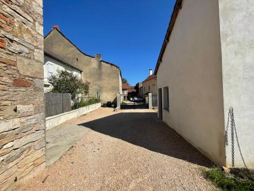 an alley between two buildings with a stone wall at L'Imprévu est une maison individuelle. in Sennecey-le-Grand